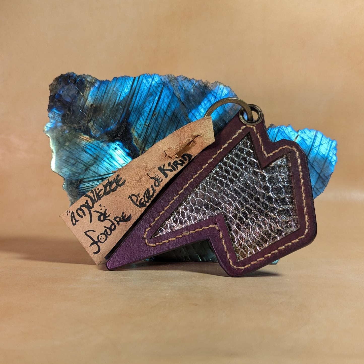 Amulette “Foudre du Kirin” en cuir tanné végétal et peau de couleuvre élaphe, montée en porte-clé ou bijou de sac.