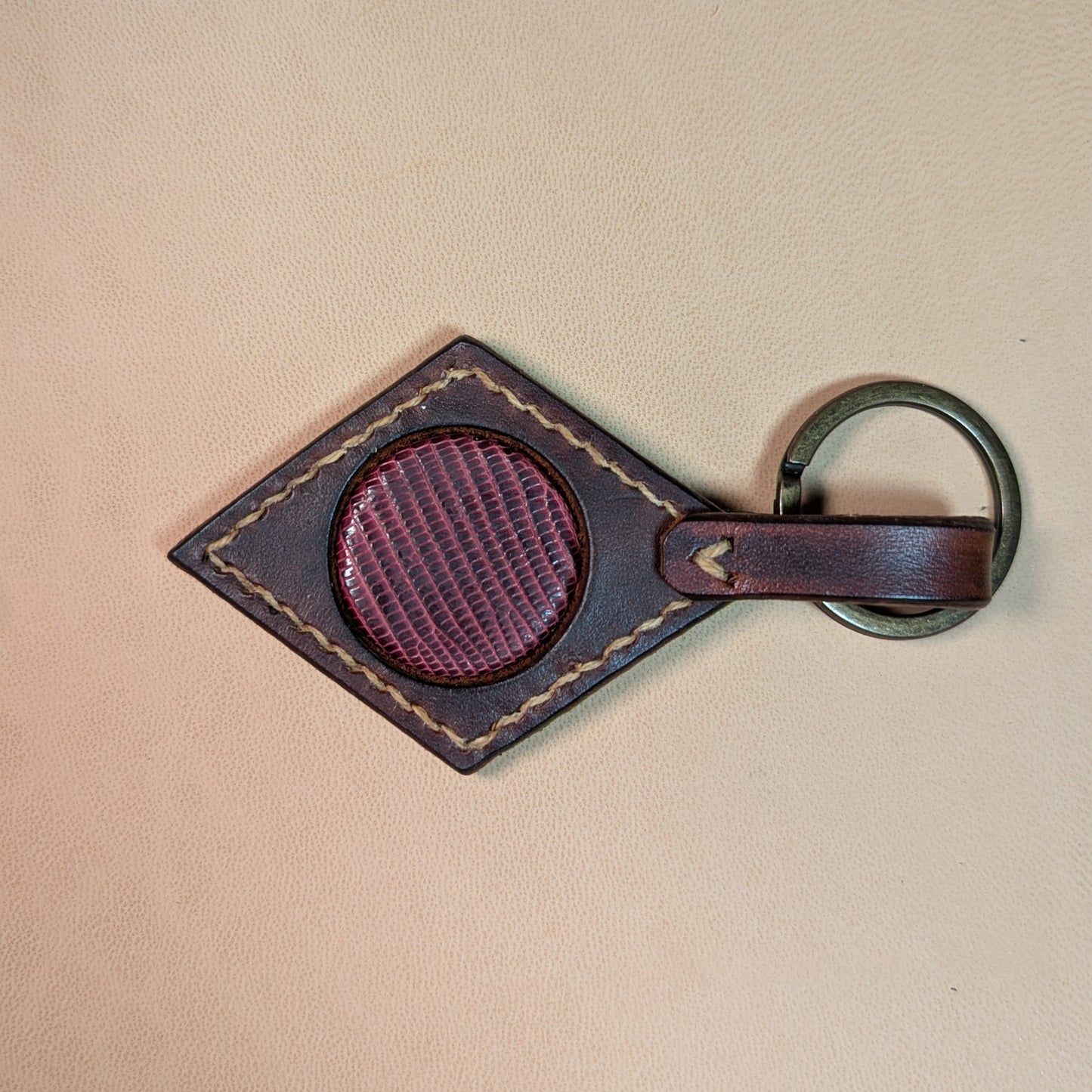 Bijou de sac ou porte-clef en cuir tanné végétal, avec médaillon en cuir exotique (crapaud, serpent, lézard, coq ou alligator), fermoir en laiton vieilli et fil de lin.