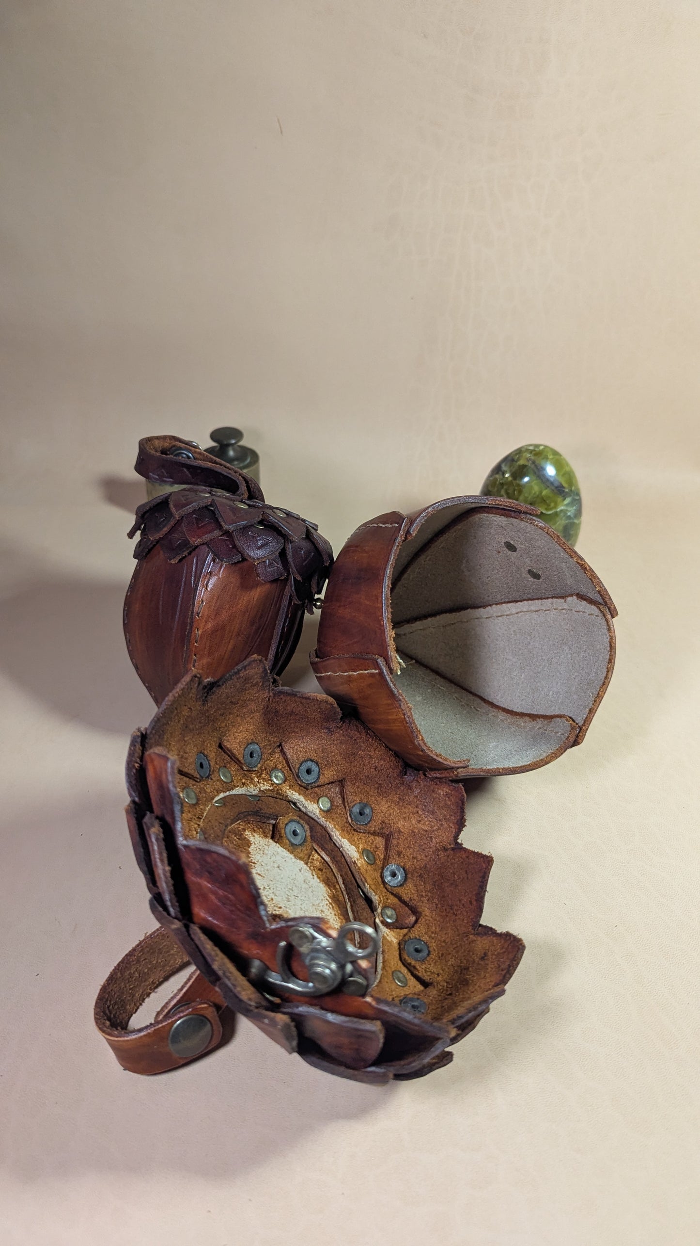 Sacoche en cuir tanné végétal, façonnée en forme de gland, avec rabat à écailles et fermoir en laiton vieilli.