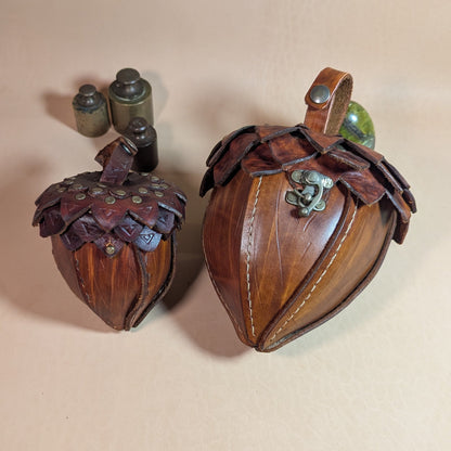 Sacoche en cuir tanné végétal, façonnée en forme de gland, avec rabat à écailles et fermoir en laiton vieilli.