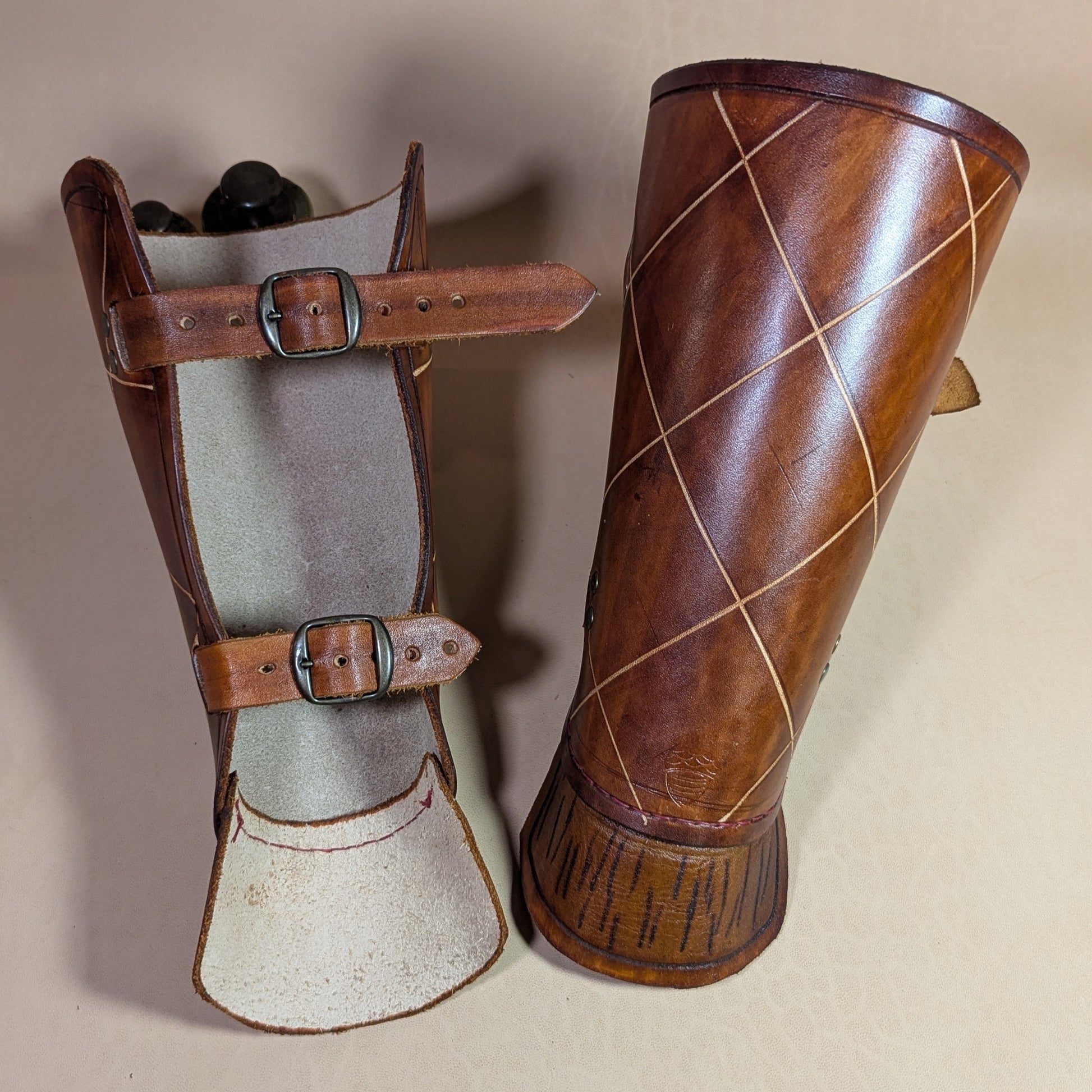 Protèges avant-bras en cuir de bovin tanné végétal, avec boucle en laiton vieilli et sangles en cuir pour un ajustement personnalisé.