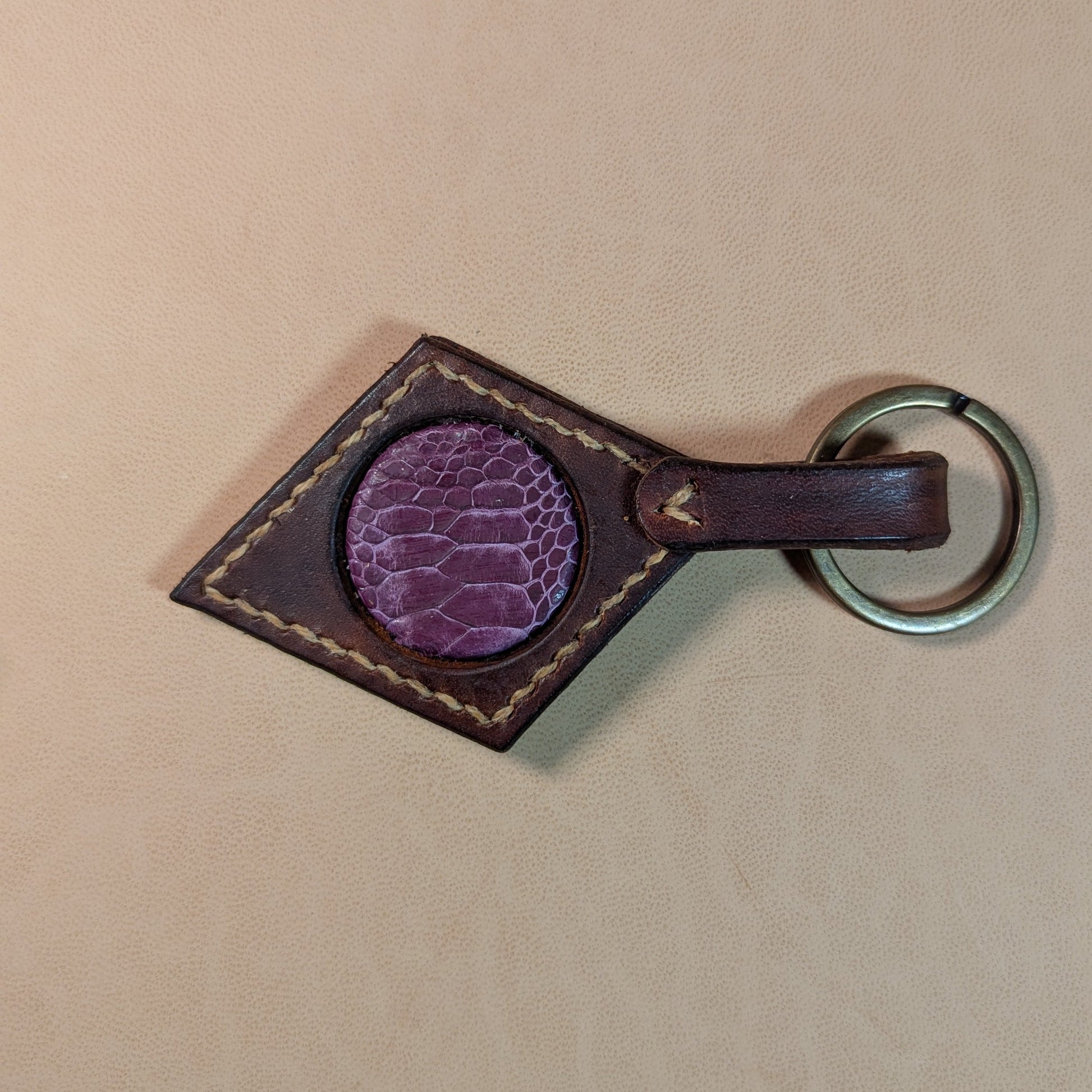 Bijou de sac ou porte-clef en cuir tanné végétal, avec médaillon en cuir exotique (crapaud, serpent, lézard, coq ou alligator), fermoir en laiton vieilli et fil de lin.