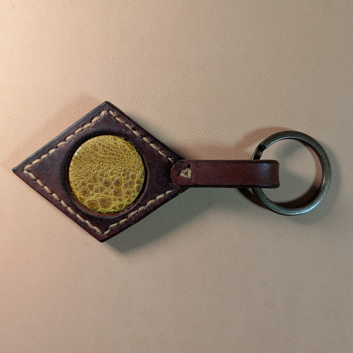 Bijou de sac ou porte-clef en cuir tanné végétal, avec médaillon en cuir exotique (crapaud, serpent, lézard, coq ou alligator), fermoir en laiton vieilli et fil de lin.