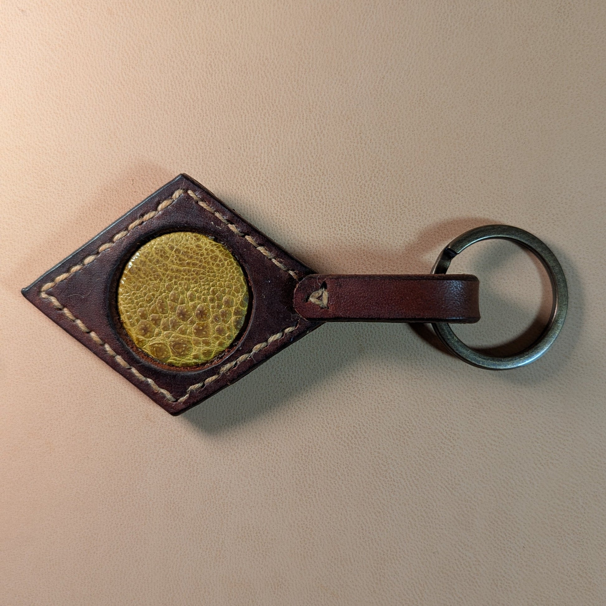 Bijou de sac ou porte-clef en cuir tanné végétal, avec médaillon en cuir exotique (crapaud, serpent, lézard, coq ou alligator), fermoir en laiton vieilli et fil de lin.