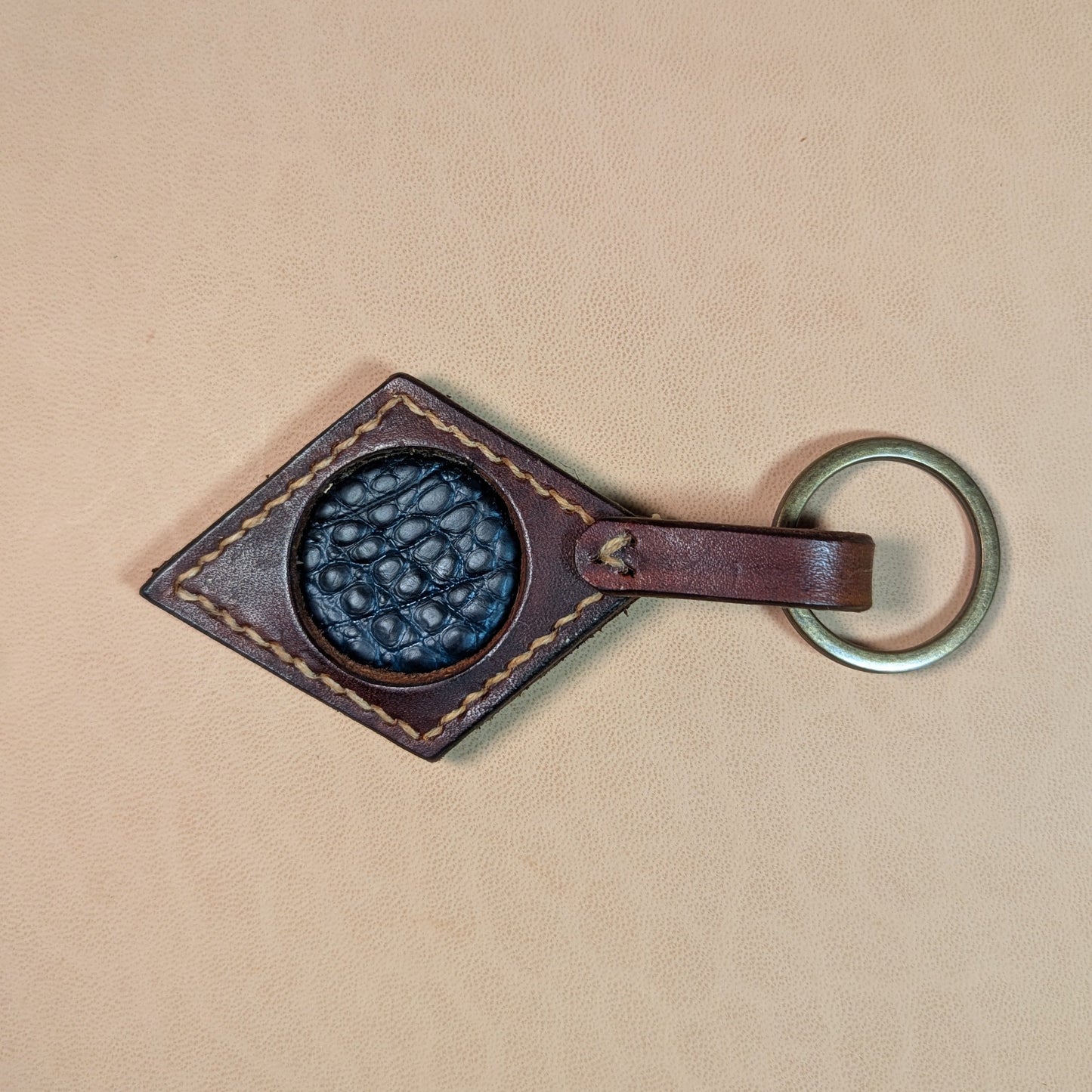 Bijou de sac ou porte-clef en cuir tanné végétal, avec médaillon en cuir exotique (crapaud, serpent, lézard, coq ou alligator), fermoir en laiton vieilli et fil de lin.