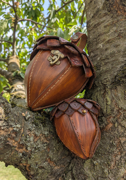 Sacoche en cuir tanné végétal, façonnée en forme de gland, avec rabat à écailles et fermoir en laiton vieilli.