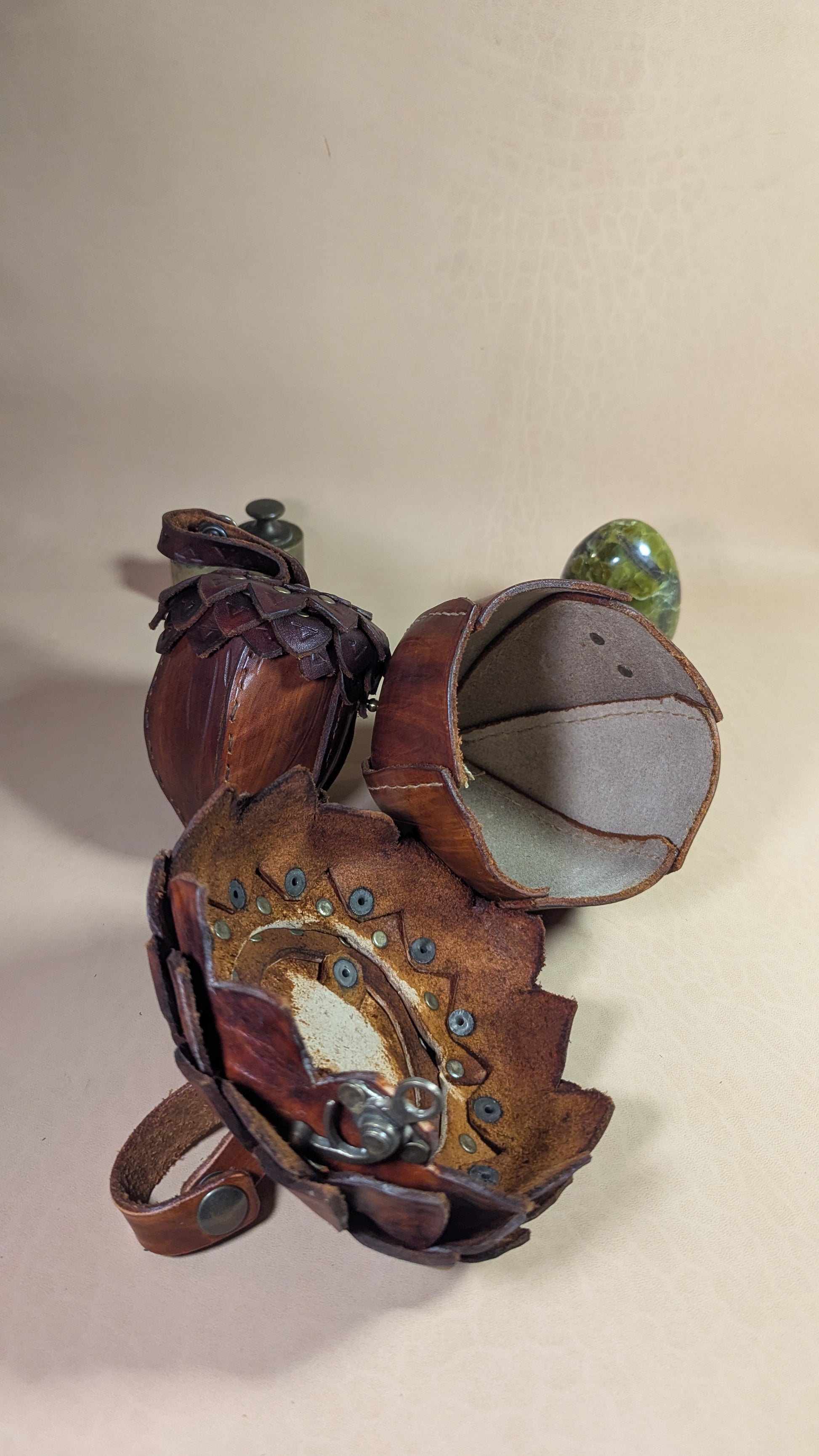 Sacoche en cuir tanné végétal, façonnée en forme de gland, avec rabat à écailles et fermoir en laiton vieilli.