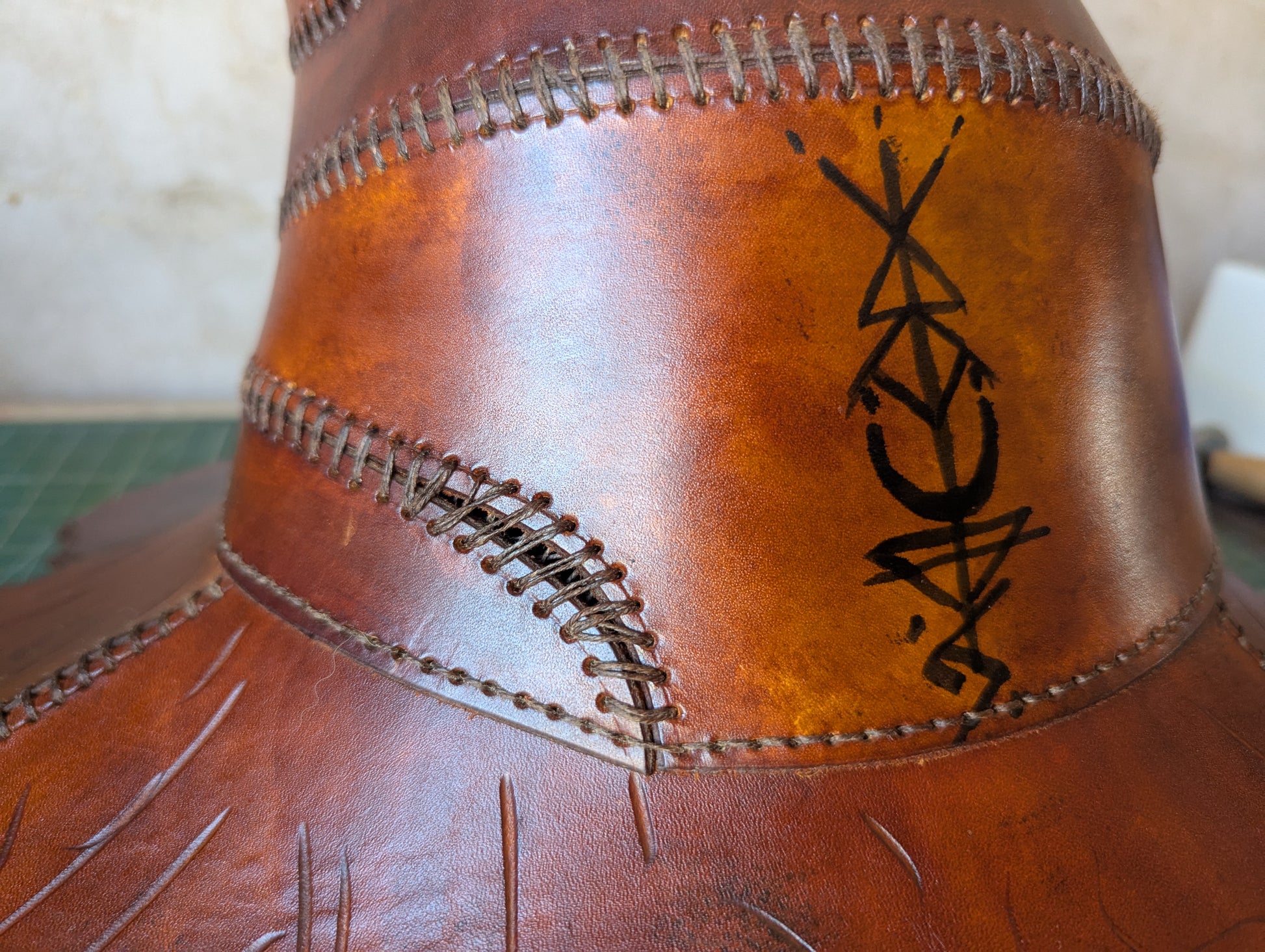 Chapeau en cuir tanné végétal, teint à la main dans des teintes boisées profondes, runes sur chapeau
