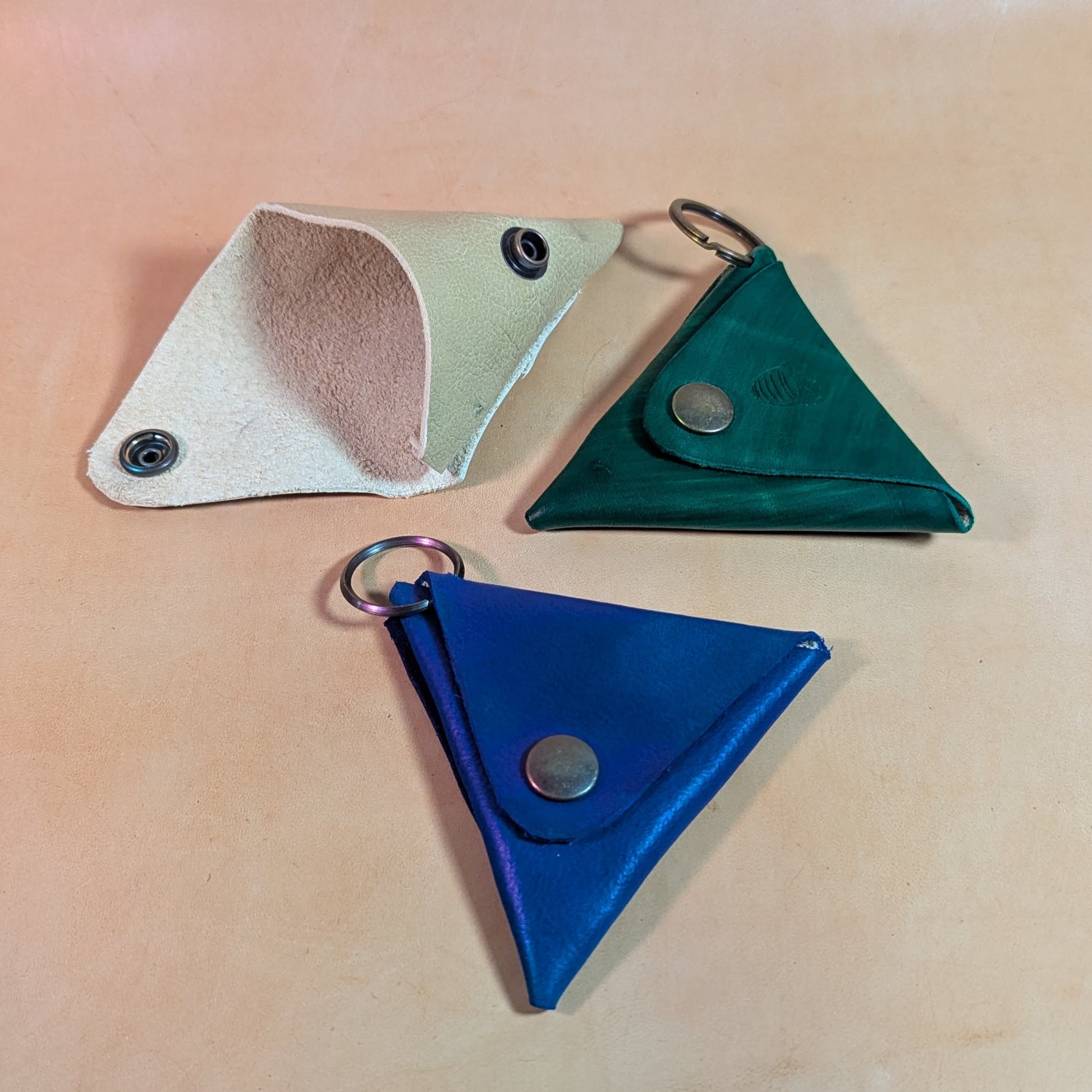 Porte-monnaies triangle en cuir bovin tanné végétal, teinté à la main, avec bouton pression fort. Personnalisable avec ou sans attache porte-clé.